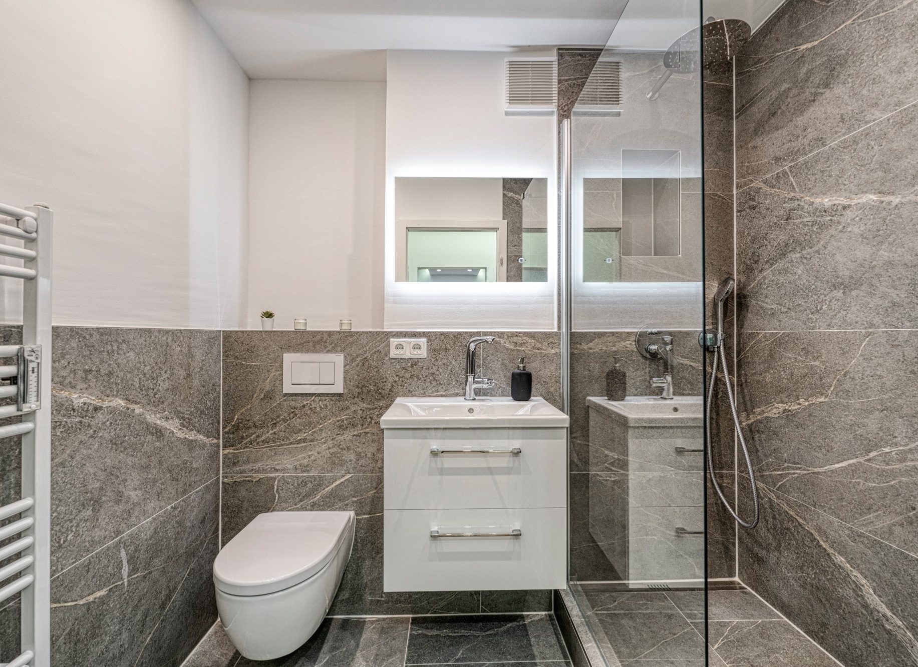 Badsanierung in München – modernes Badezimmer mit anthrazitfarbenen Fliesen und wandhängendem WC